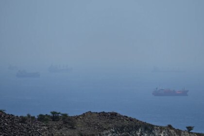 Imagen de un buque de guerra en el estrecho de Ormuz, con la bandera de Irán al fondo