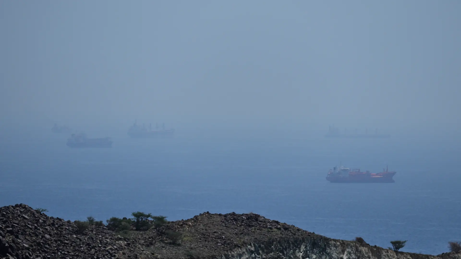 Imagen de un buque de guerra en el estrecho de Ormuz, con la bandera de Irán al fondo