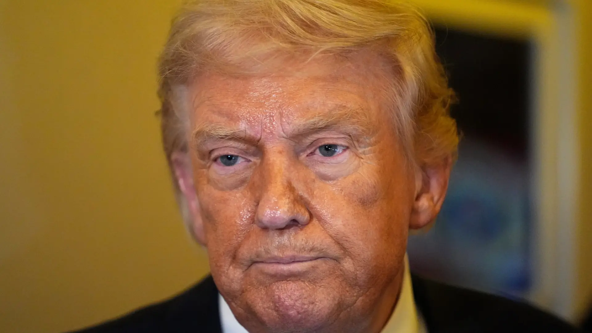 Gráfico de barras mostrando la aprobación de Trump en EEUU con una flecha hacia abajo, junto a una imagen de mapa de Irán.