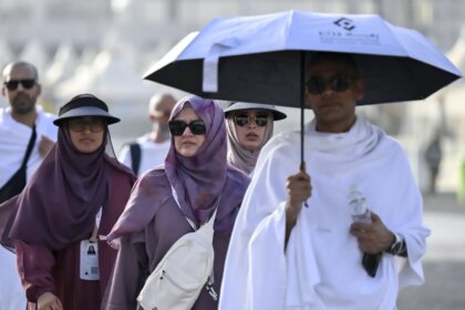 Peregrinos llegando a La Meca para el Aíd al Adha con banderas y estandartes