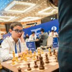 Faustino Oro jugando ajedrez con piezas de ajedrez en un tablero