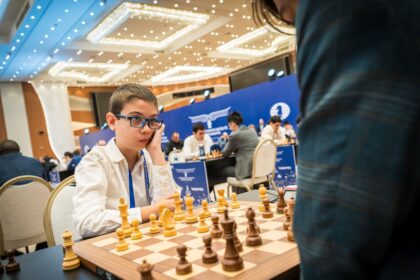 Faustino Oro jugando ajedrez con piezas de ajedrez en un tablero