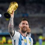 Lionel Messi sonriendo y sosteniendo un trofeo de fútbol