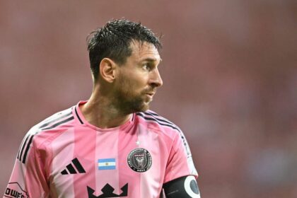 Lionel Messi en acción durante un partido de fútbol con una expresión de dolor en su rostro