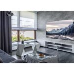 Una imagen de un estadio de fútbol con una pantalla gigante de TV OLED 4K mostrando un partido emocionante