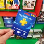 Persona sostiene un mando de PlayStation con un fondo de dinero y un gráfico de precios en aumento