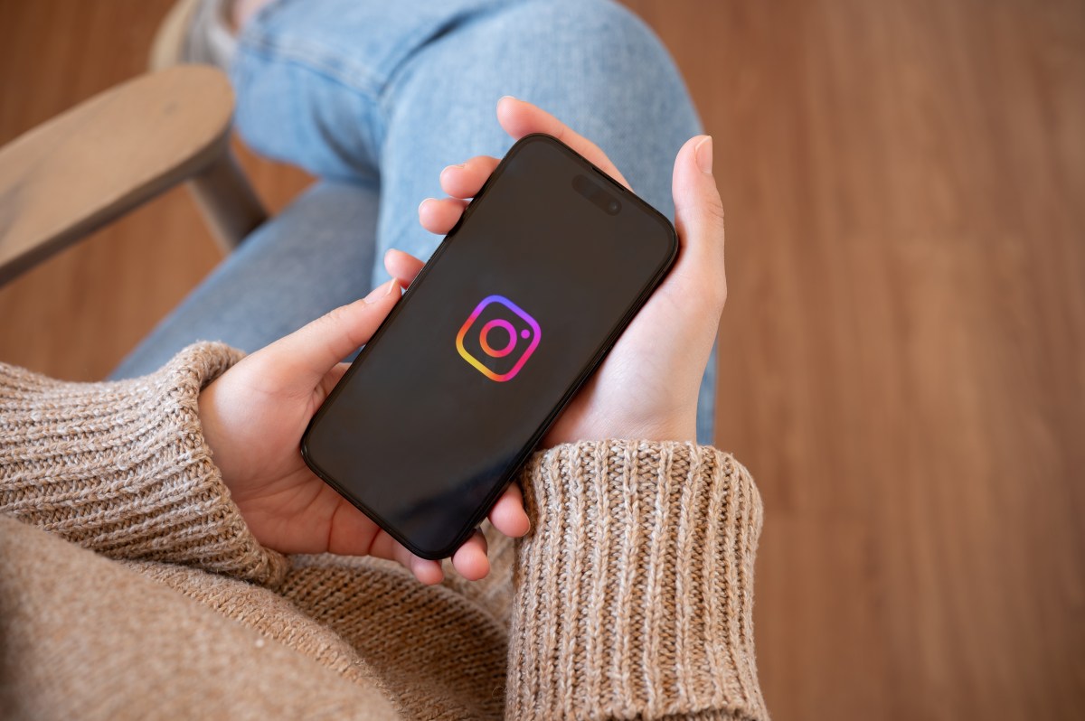 Una persona mirando un Reel en Instagram con una lupa en la mano