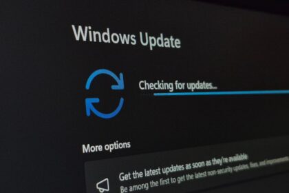 Una persona frente a una computadora con una pantalla de carga de actualización de Windows
