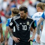 Jugadores de Argentina y Islandia en un partido de fútbol, con un estadio de fondo