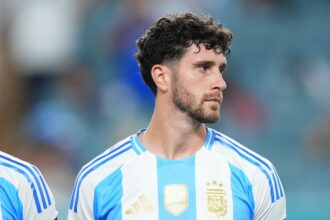 Marcos Senesi en acción durante un partido de fútbol, con la camiseta de la selección argentina