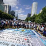 Hinchada argentina en el Klyde Warren Park de Dallas con banderas y camisetas celestes y blancas