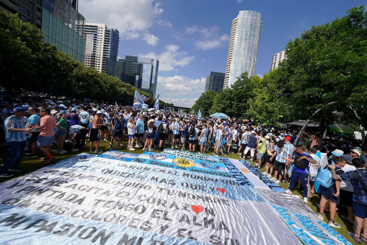 Hinchada argentina en el Klyde Warren Park de Dallas con banderas y camisetas celestes y blancas
