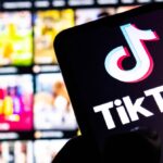 Una persona sostiene un teléfono con la app de TikTok abierta, mostrando un marcador de fútbol en tiempo real