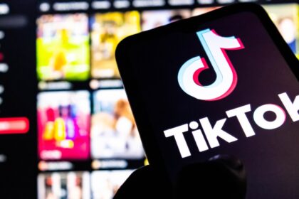 Una persona sostiene un teléfono con la app de TikTok abierta, mostrando un marcador de fútbol en tiempo real